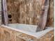 A relaxing soaking tub with beautiful, brown tile work and rustic-looking curtain at 16535 W 79Th Dr, Arvada, CO 80007
