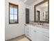 Bright bathroom featuring a white vanity with marble countertop and view from the window at 16535 W 79Th Dr, Arvada, CO 80007