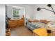 Cozy bedroom with natural light, wooden dresser, soft carpet, and outdoor view at 16535 W 79Th Dr, Arvada, CO 80007