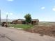 Charming brick home featuring a well-maintained lawn, mature tree, and unique mining cart decor at 16535 W 79Th Dr, Arvada, CO 80007
