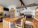 A kitchen island with a wooden countertop and seating that overlooks an open living area with a fireplace and large windows at 16535 W 79Th Dr, Arvada, CO 80007