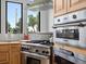 Kitchen featuring stainless steel appliances, wood cabinets, and a window overlooking the yard at 16535 W 79Th Dr, Arvada, CO 80007
