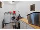 A laundry room with stainless steel utility sinks, washer and dryer, and a countertop at 16535 W 79Th Dr, Arvada, CO 80007