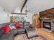 Open-concept living room with vaulted ceiling, wood floors, leather sectional, fireplace, and access to the kitchen at 16535 W 79Th Dr, Arvada, CO 80007