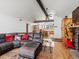 Open-concept living room with vaulted ceiling, wood floors, leather sectional, fireplace, and access to the kitchen at 16535 W 79Th Dr, Arvada, CO 80007