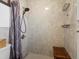 Stylish shower with gray tiling, rainfall showerhead, and a built-in bench at 16535 W 79Th Dr, Arvada, CO 80007