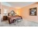 Bedroom with carpet, peach walls, and furnishings including a bed, bench, and side tables at 1900 E Girard Pl # 908, Englewood, CO 80113