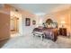 Bedroom with carpet, peach walls, and furnishings including a bed, bench, and side tables at 1900 E Girard Pl # 908, Englewood, CO 80113