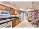 Spacious kitchen featuring oak cabinets, tile flooring, a table with chairs, and stainless steel appliances at 1900 E Girard Pl # 908, Englewood, CO 80113