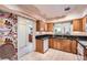 Traditional kitchen with oak cabinets, granite countertops, and tile flooring with adjacent doorway at 1900 E Girard Pl # 908, Englewood, CO 80113