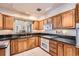 Traditional kitchen with oak cabinets, black countertops, white appliances, and tile flooring at 1900 E Girard Pl # 908, Englewood, CO 80113