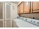 Laundry room with washer, dryer, and upper cabinets providing practical storage solutions at 1900 E Girard Pl # 908, Englewood, CO 80113