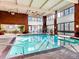 Bright indoor swimming pool with floor-to-ceiling windows and brick accents at 1900 E Girard Pl # 908, Englewood, CO 80113