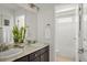 Bright bathroom featuring double sinks, dark wood cabinets and a shower with white curtains at 3476 Beeler Ct, Denver, CO 80238