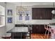 Open kitchen and dining area with dark cabinets, pendant lighting, and hardwood floors at 3476 Beeler Ct, Denver, CO 80238
