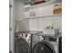 Bright laundry area features a modern washer and dryer, complemented by white shelving at 3476 Beeler Ct, Denver, CO 80238