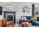 Cozy living room with a fireplace, plush blue sectional, and hardwood floors at 3476 Beeler Ct, Denver, CO 80238