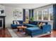 Stylish living room featuring a blue sectional, large windows, and hardwood floors at 3476 Beeler Ct, Denver, CO 80238