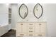 Bright bathroom featuring a dual vanity with white marble countertop and decorative, oval framed mirrors at 469 Tripp Dr, Golden, CO 80401