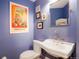 Charming half bathroom featuring artistic prints, blue walls and a pedestal sink with chrome fixtures at 469 Tripp Dr, Golden, CO 80401