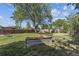 Fenced backyard featuring grass, mature trees, and garden boxes at 8641 Lowell Blvd, Westminster, CO 80031