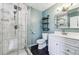 Modern bathroom with glass enclosed shower, white vanity, black tile floors and blue accent wall at 8641 Lowell Blvd, Westminster, CO 80031