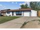 Exterior view of single-story home featuring a well-manicured lawn and long driveway at 8641 Lowell Blvd, Westminster, CO 80031