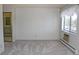 Bright bedroom with neutral carpet, a window with blinds, and a view of the bathroom at 14152 E Linvale Pl # 311, Aurora, CO 80014