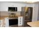 Updated kitchen with stainless steel appliances, white cabinetry, and ample counter space at 14152 E Linvale Pl # 311, Aurora, CO 80014