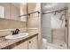 Bathroom with a shower, granite counter, tile backsplash, cream cabinets, and dark bronze hardware at 1062 Pinon Ln, Elizabeth, CO 80107