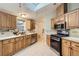 Charming kitchen with light wood cabinets, stainless steel appliances, and a skylight overhead at 1062 Pinon Ln, Elizabeth, CO 80107