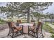 Outdoor stone patio with comfortable seating around a covered fire pit at 1062 Pinon Ln, Elizabeth, CO 80107