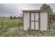 Exterior shot of a shed with a white and brown painted door, situated near a fenced yard at 1062 Pinon Ln, Elizabeth, CO 80107