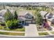 Overhead view of a house with manicured landscaping, a three-car garage, and a nearby community park at 23580 E Portland Way, Aurora, CO 80016