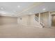 Spacious finished basement features neutral carpet, recessed lighting, and stairs to the main level at 23580 E Portland Way, Aurora, CO 80016