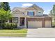 Charming two-story home with brick accents, a three-car garage, and a well-manicured lawn at 23580 E Portland Way, Aurora, CO 80016
