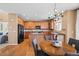 Traditional eat-in kitchen showcasing wood cabinets, hardwood floors, black appliances, and a center island at 23580 E Portland Way, Aurora, CO 80016