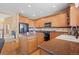 Well-lit kitchen featuring wood cabinetry, granite countertops, a black range, and an island workspace at 23580 E Portland Way, Aurora, CO 80016