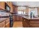 Spacious kitchen boasts wooden cabinets, granite counters, stainless steel appliances, and hardwood flooring at 23580 E Portland Way, Aurora, CO 80016