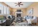 Inviting living room featuring a brick fireplace, ceiling fan, and comfortable seating with natural lighting at 23580 E Portland Way, Aurora, CO 80016