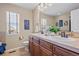 Main bathroom featuring dual sinks, cherry cabinets, and a large mirror that enhances the natural light at 23580 E Portland Way, Aurora, CO 80016