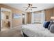 Main bedroom featuring soft carpet, ceiling fan, access to ensuite bathroom and a walk-in closet for optimal convenience at 23580 E Portland Way, Aurora, CO 80016