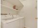 Bright laundry room featuring a modern washer and dryer set with built-in shelving for easy access at 13992 E Marina Dr # 109, Aurora, CO 80014