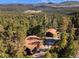 Breathtaking aerial view of a mountain home nestled amongst a dense forest with scenic views at 31084 Kings Valley Dr, Conifer, CO 80433