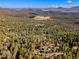 Expansive aerial view of the property nestled within a dense forest landscape at 31084 Kings Valley Dr, Conifer, CO 80433