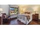 Inviting bedroom with warm wood floors, large window, and plush bedding at 31084 Kings Valley Dr, Conifer, CO 80433