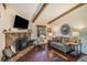 Inviting living room featuring a stone fireplace, hardwood floors, and comfortable seating area at 31084 Kings Valley Dr, Conifer, CO 80433