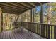 Relax on this cozy wooden porch with forest views and comfortable seating at 31084 Kings Valley Dr, Conifer, CO 80433