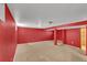 An empty basement with a red-painted wall and beige carpet at 436 Pluto Ct, Lone Tree, CO 80124