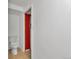 A white bathroom with a toilet and doorway trimmed in red at 436 Pluto Ct, Lone Tree, CO 80124